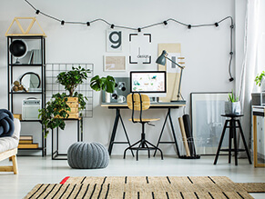 Black_white_home_office_fairy_lights_woven_rug_metal_shelfs_plants_ottoman_timber_chair_mac